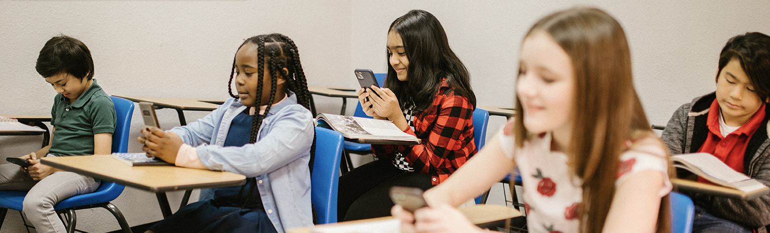 Students Sitting Inside the Classroom While Using Their Smartphone